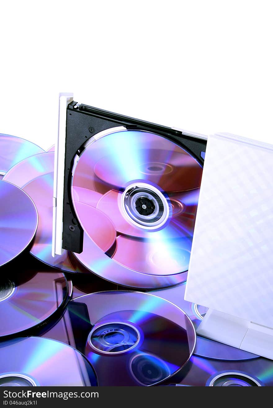 Poratble CD-RW/DVD-RW device with a disc inside & many discs with reflections on the  bottom cd's