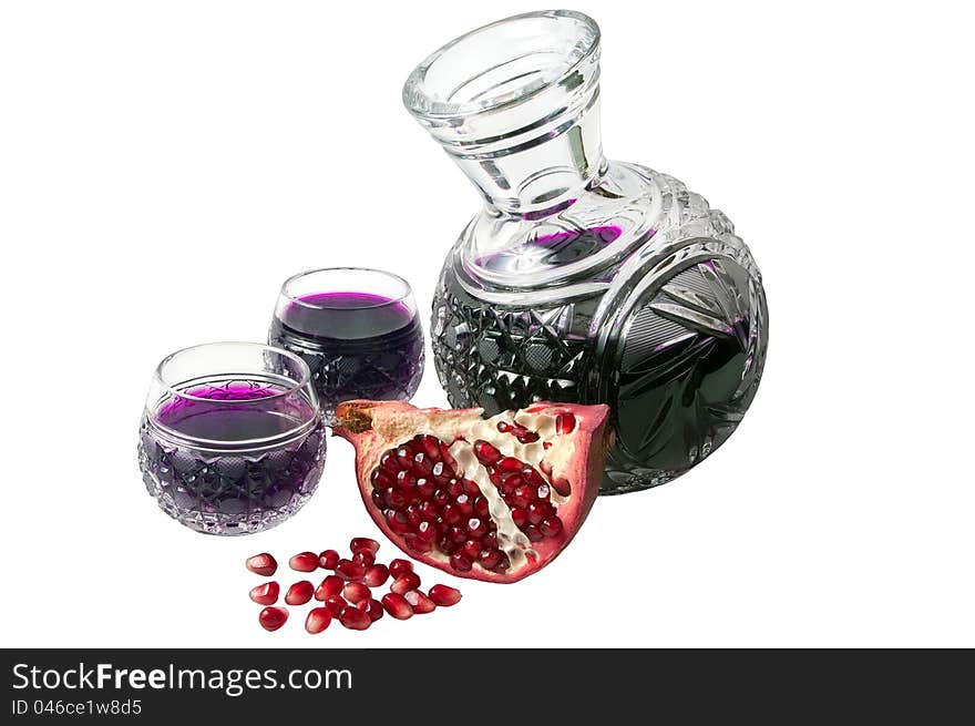 Decanter with garnet juice and pomegranate parts isolated on the white