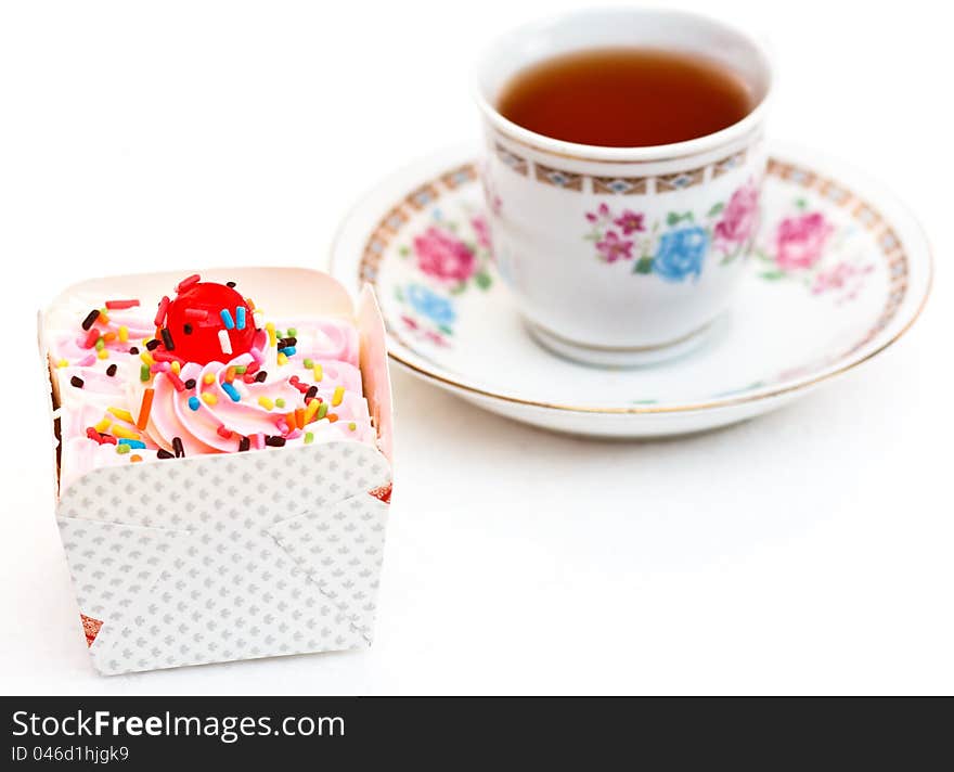 The sweets cupcake and tea are refreshments. The sweets cupcake and tea are refreshments