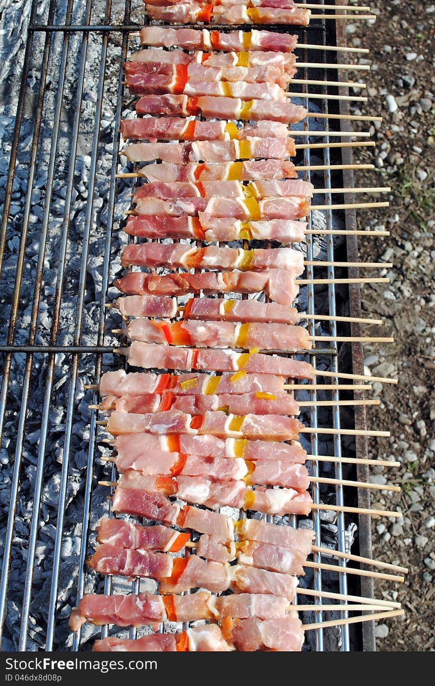 Raw pork kabobs grill on skewers on a barbecue