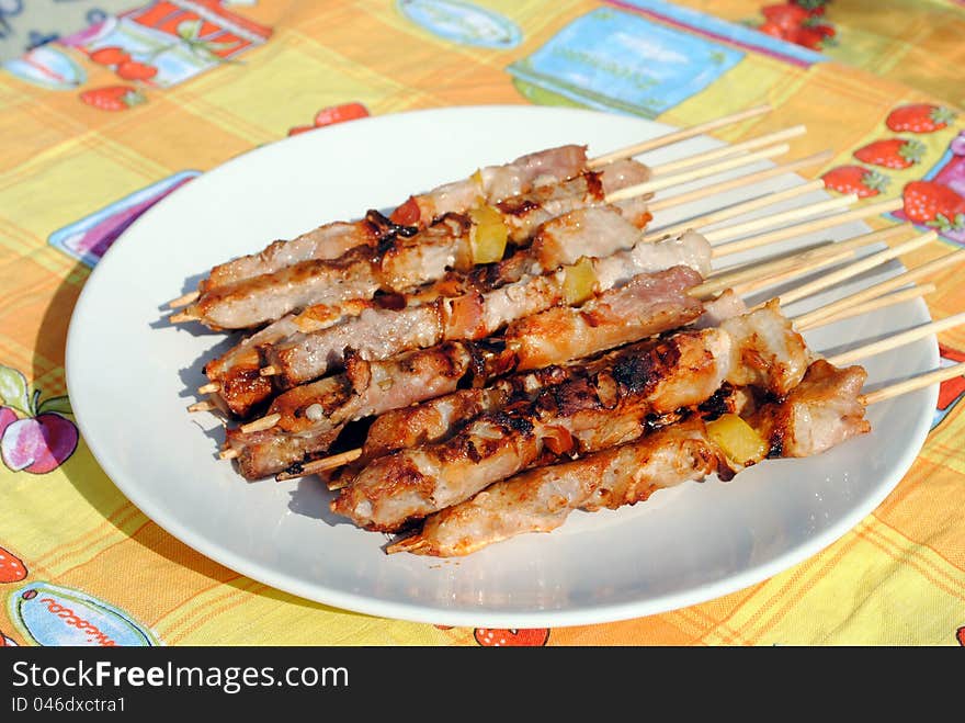 Cocked pork kabobs grilled on skewers in a plate