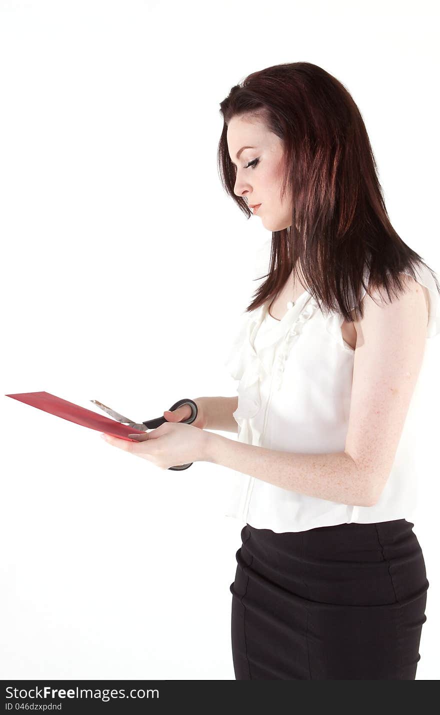 A young woman cutting a piece of card. A young woman cutting a piece of card