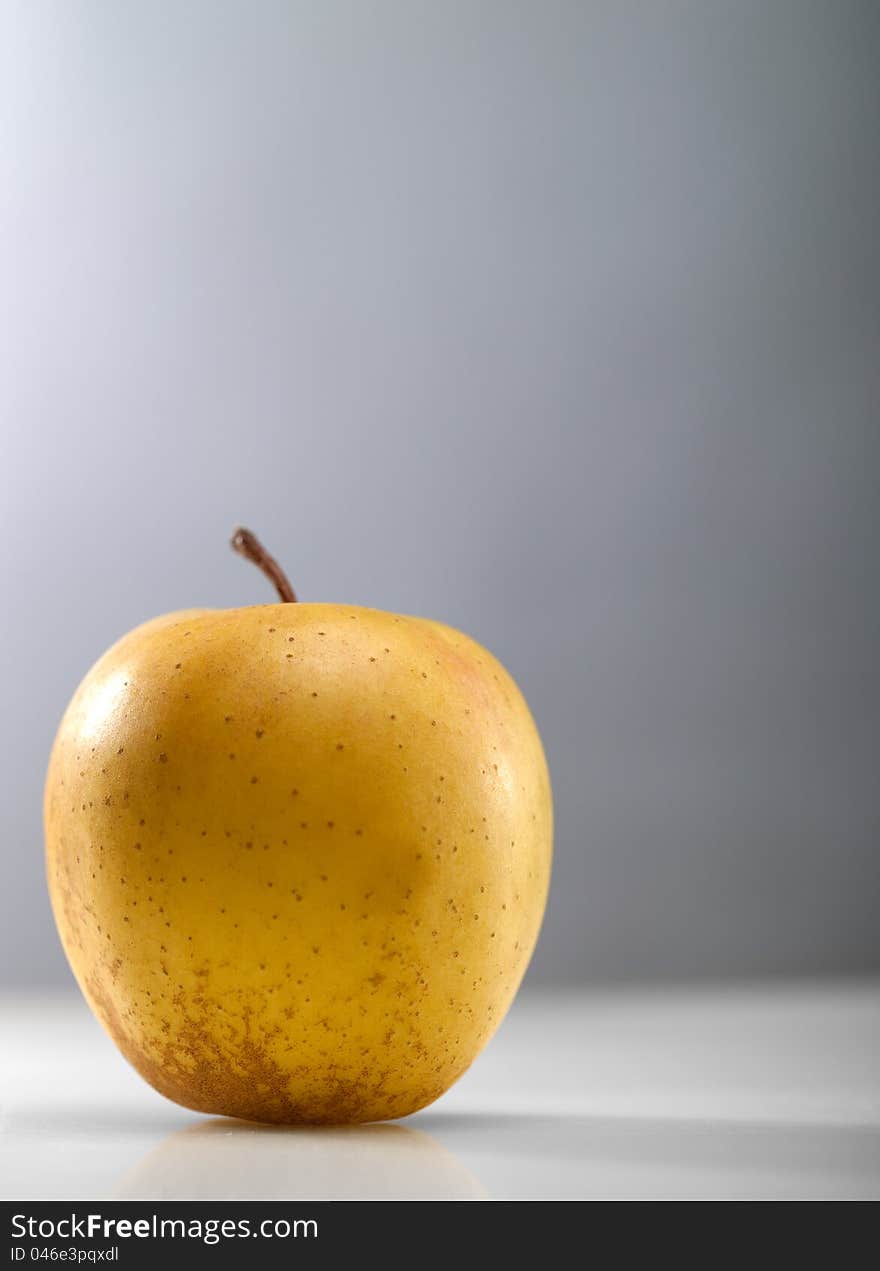 Golden apple over abstract gray backgrounds