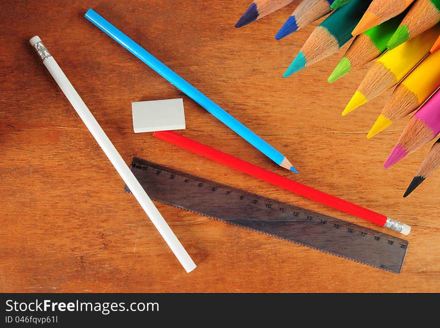 Color pencils and drawing objects on a wooden desk. Color pencils and drawing objects on a wooden desk.