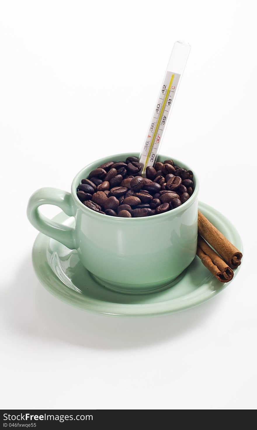 Coffee bean in the coffee cup served with cinnamon and termometer, shot with coffee bean background. Coffee bean in the coffee cup served with cinnamon and termometer, shot with coffee bean background