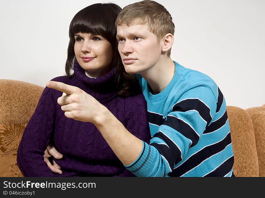 The guy with the girl pointed to the side, sitting on the couch. The guy with the girl pointed to the side, sitting on the couch