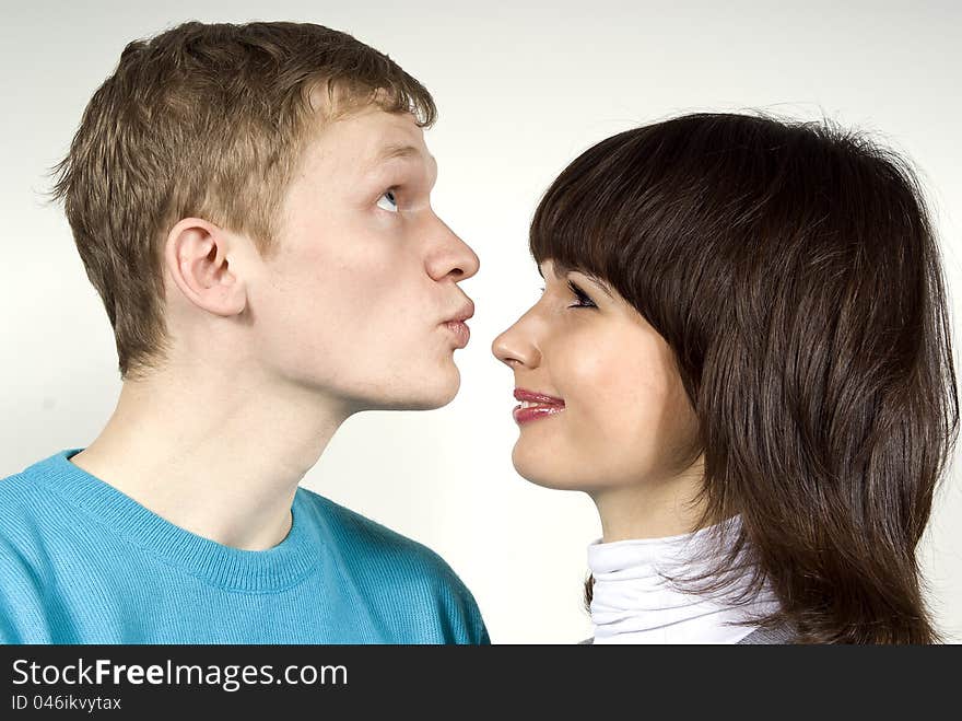 The guy kisses in the nose of a girl, a white background. The guy kisses in the nose of a girl, a white background