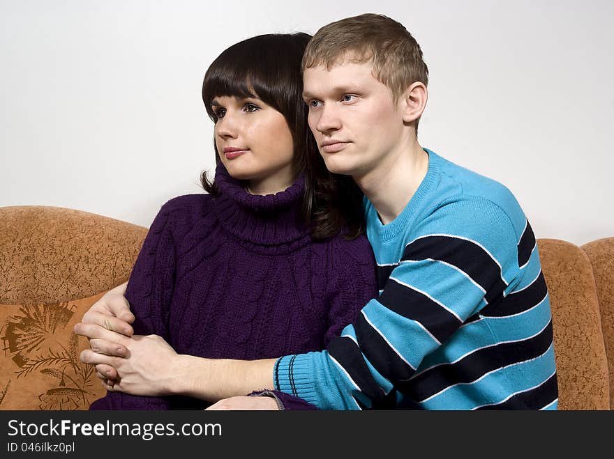 The guy hugging a girl, sitting on the couch. The guy hugging a girl, sitting on the couch