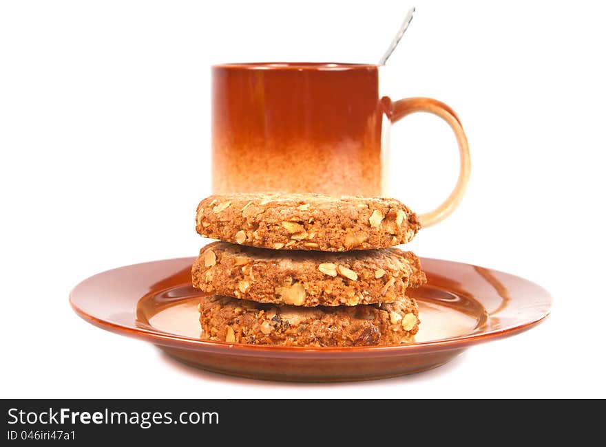 Several oat biscuits with peanuts and dried apricots on a plate on a white background. Several oat biscuits with peanuts and dried apricots on a plate on a white background..