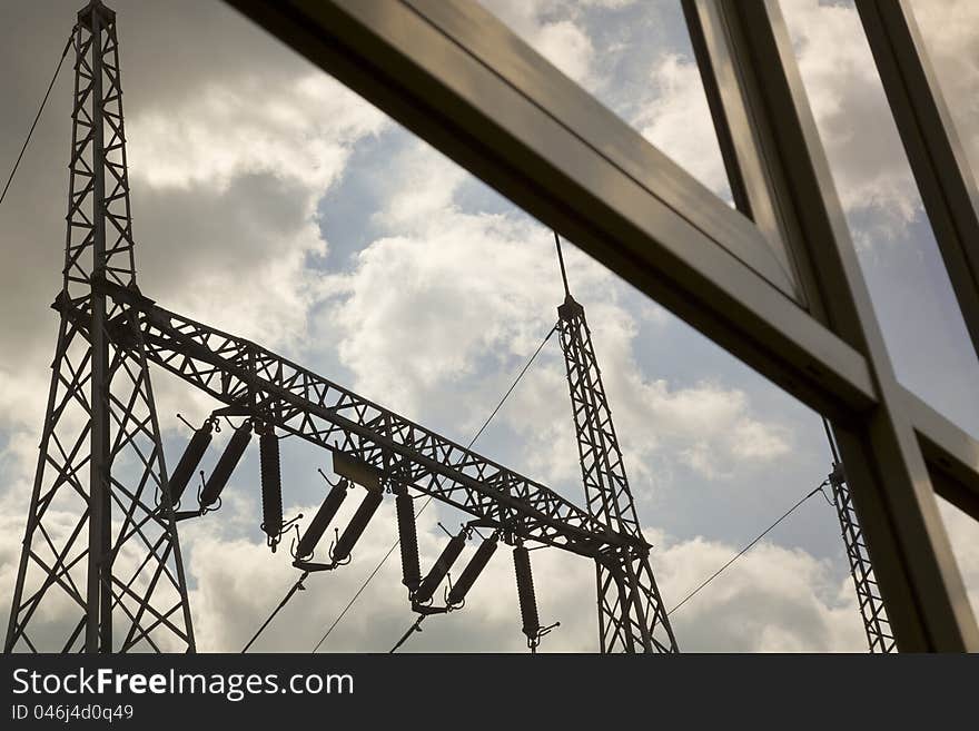 Reflection of power pylons in glasses of a building