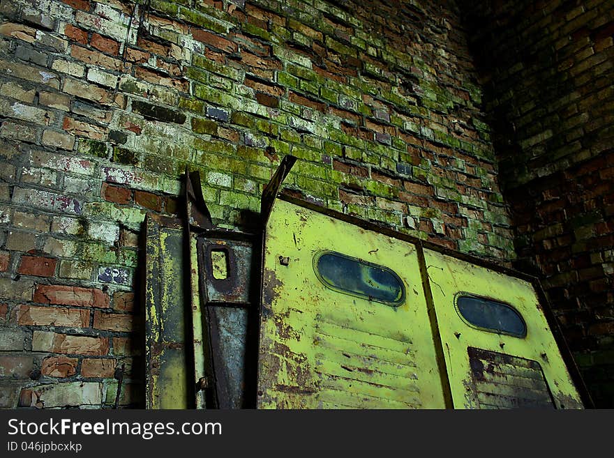 Old steel door leaning against a brick wall cracked. Old steel door leaning against a brick wall cracked