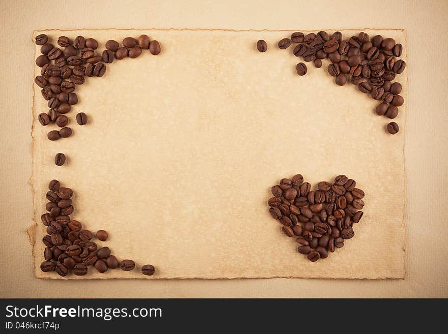 A frame and a heart symbol made from coffee crops on hand-made paper, plenty of place for text