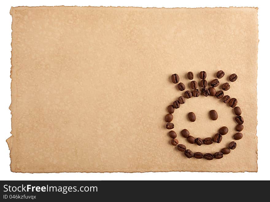 Childish smiley face symbol made from coffee crops on hand-made paper and isolated on white. Place for text. Childish smiley face symbol made from coffee crops on hand-made paper and isolated on white. Place for text.