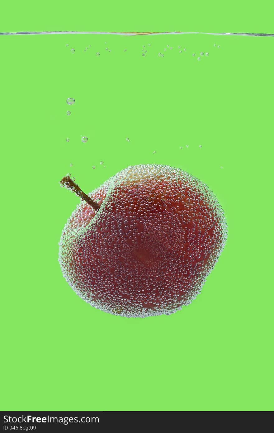 Red Apple in container of water - isolated on green with air bubbles. Red Apple in container of water - isolated on green with air bubbles