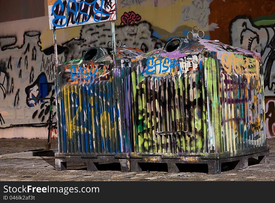 Picture of two tagged trashcans in a city. Picture of two tagged trashcans in a city