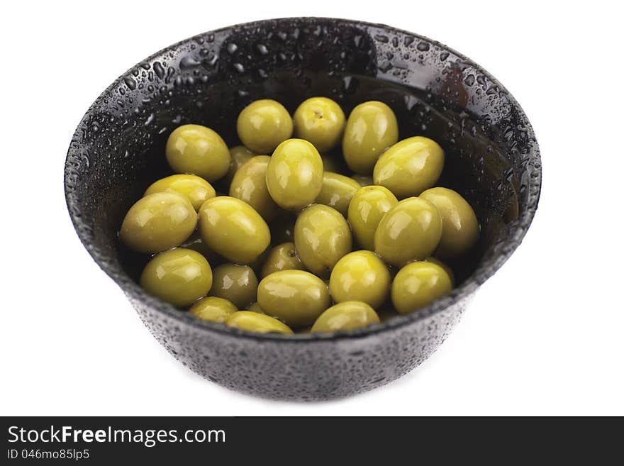 Some green olives in a bowl on white. Some green olives in a bowl on white