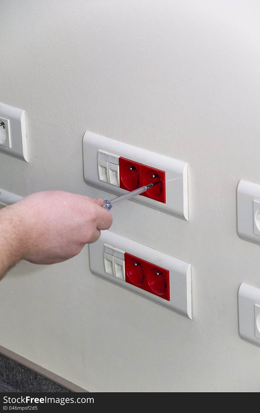 Close-up of human hand unrolling electrical socket. Close-up of human hand unrolling electrical socket