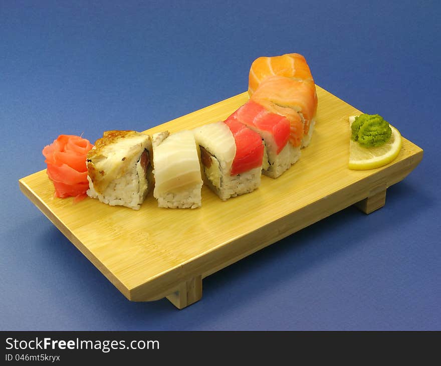 Delicious sushi with salmon and eel on wooden plate.