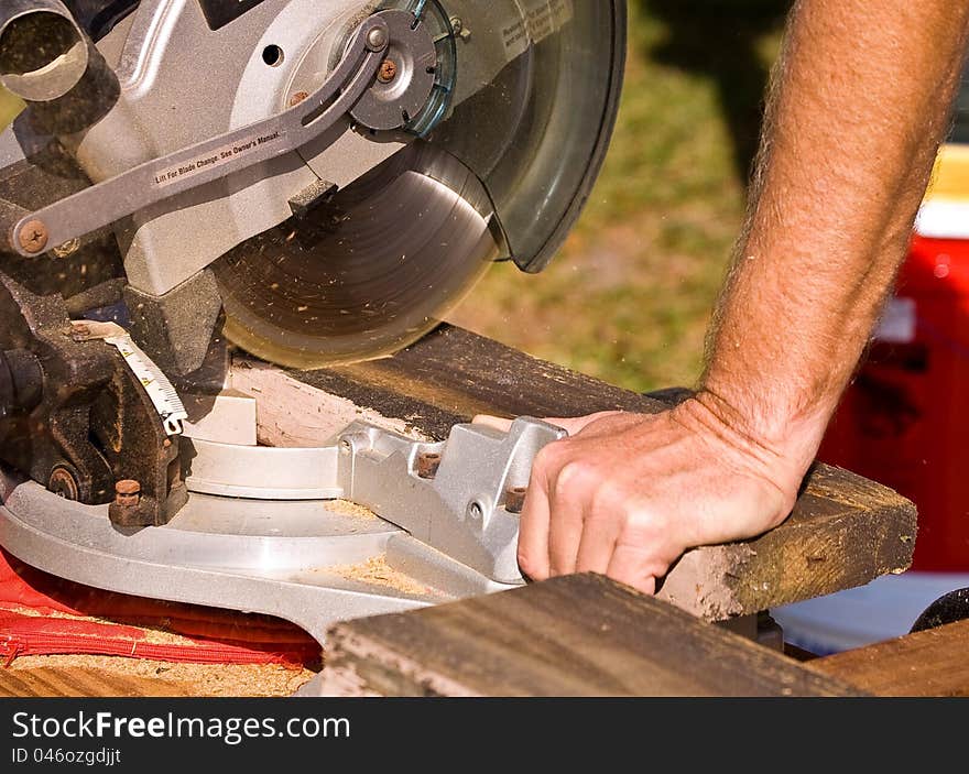 Using a miter saw to cut wood.