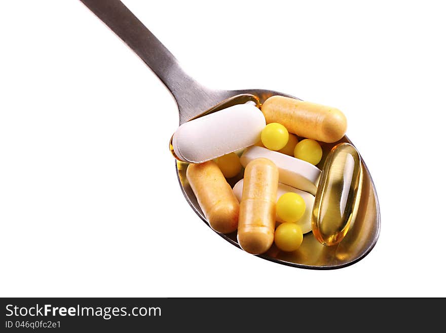 Spoon with tablets and capsules