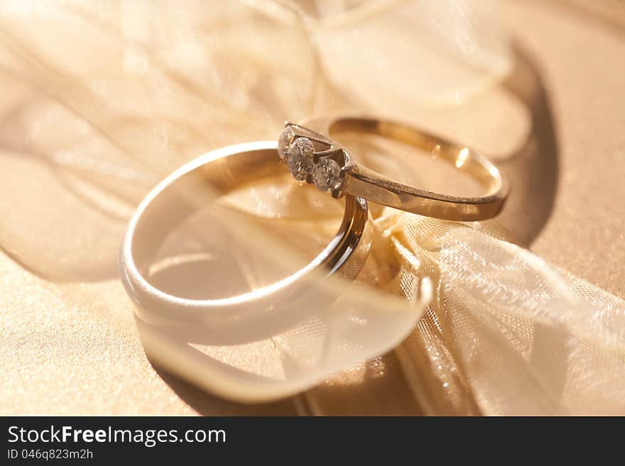 Two gold wedding rings with diamond with tender ribbon around. Two gold wedding rings with diamond with tender ribbon around