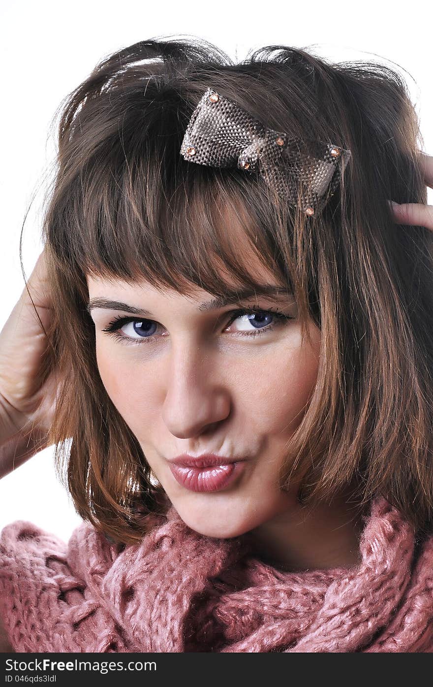 Closeup portrait of beautiful girl in pink scarf gives a kiss