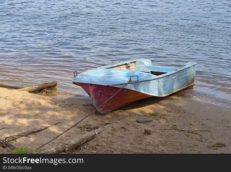 Old aluminum boat on the sandy riverbank. Old aluminum boat on the sandy riverbank