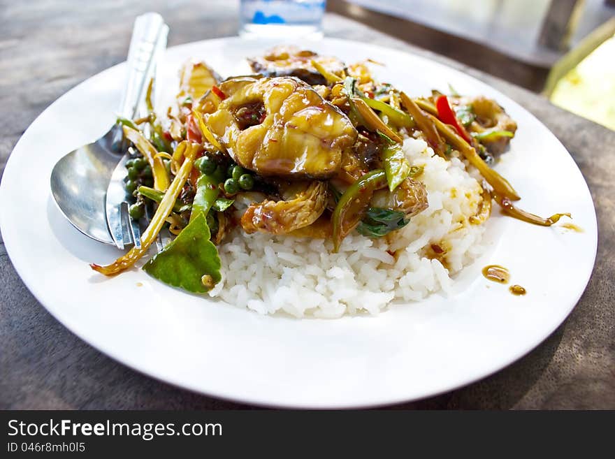 Fried fish topped with spicy rice.