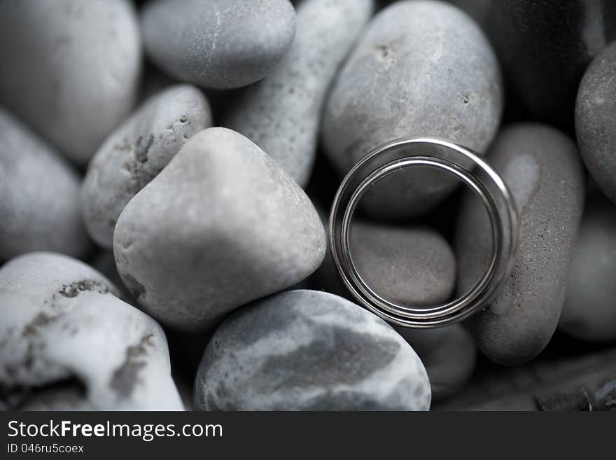 Wedding rings on sea stone background