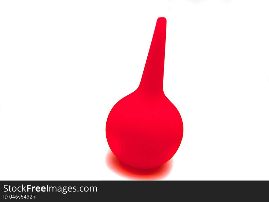 Red enema syringe on white background