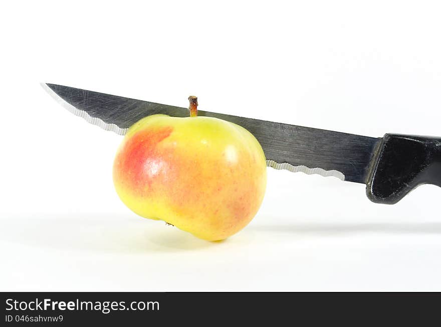 Cutting the mini organic lady apple with knife. Cutting the mini organic lady apple with knife