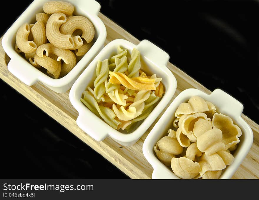 Three sorts of uncooked pasta on a black background. Three sorts of uncooked pasta on a black background