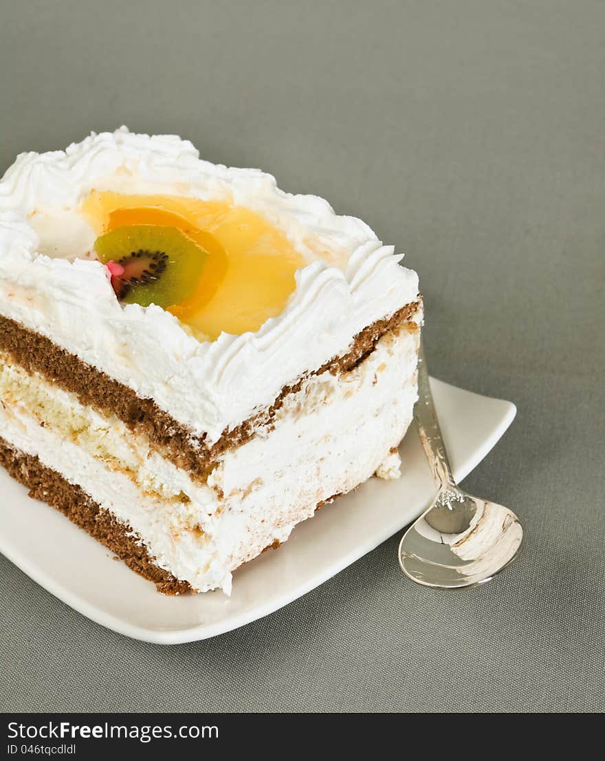 Cake lies on a saucer and tea spoon