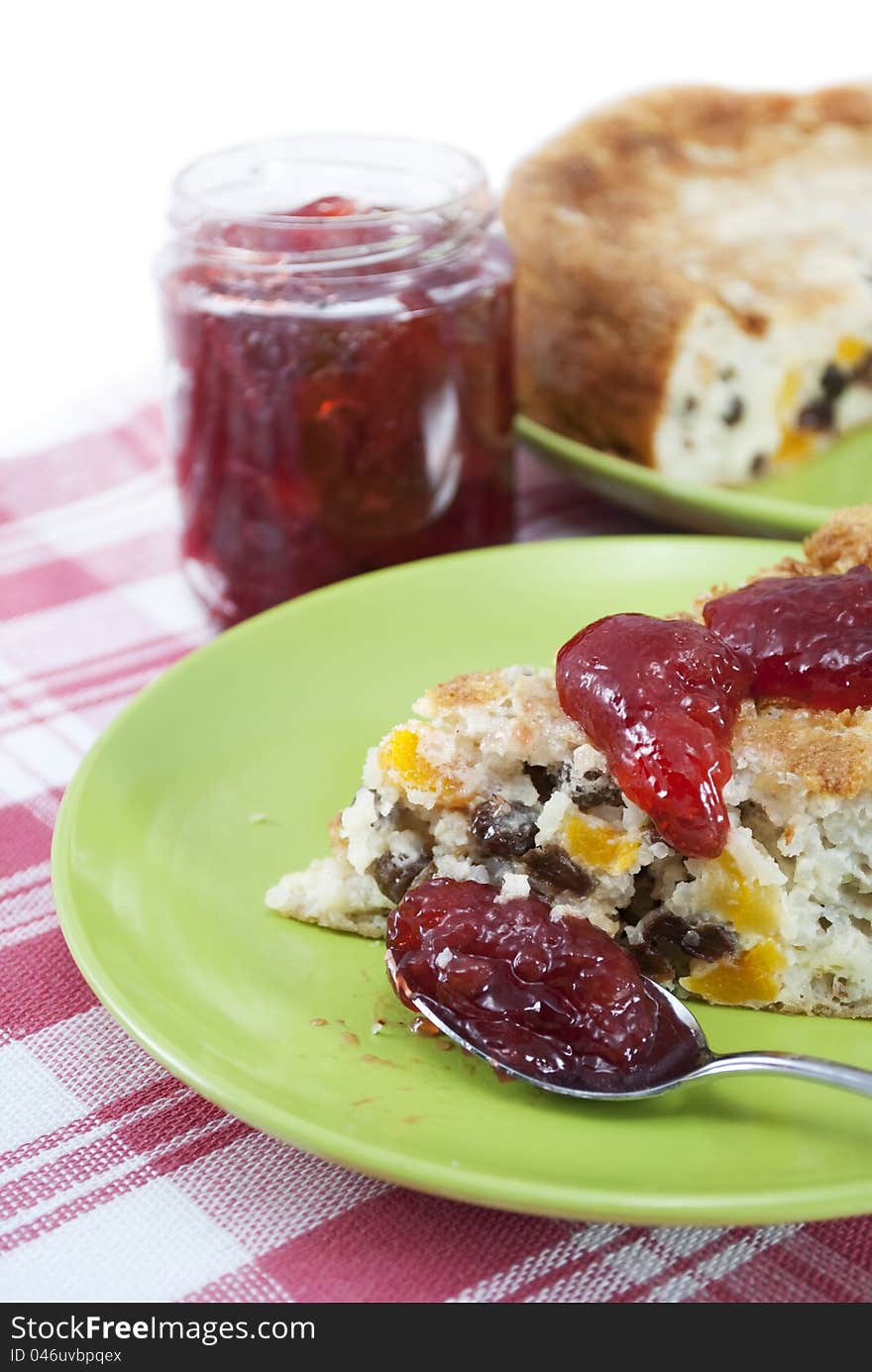 Rice pudding with raisins and dried apricots with strawberry jam.  on white .