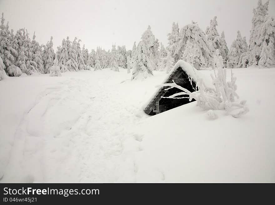 Mountain in winter, spring, winter hiking trail around the well, the beaten tracks in the snow, trees coated with snow, winter landscape with retracted air. Mountain in winter, spring, winter hiking trail around the well, the beaten tracks in the snow, trees coated with snow, winter landscape with retracted air