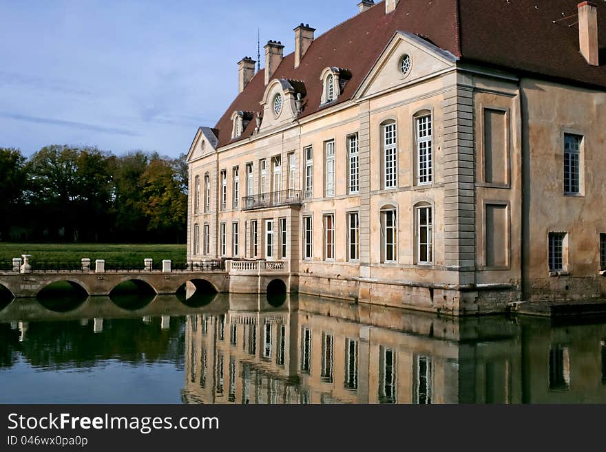 The chateau de Commarin (castle) is located in Burgundy, France. The castle is moated and a bridge leads to its entrance.