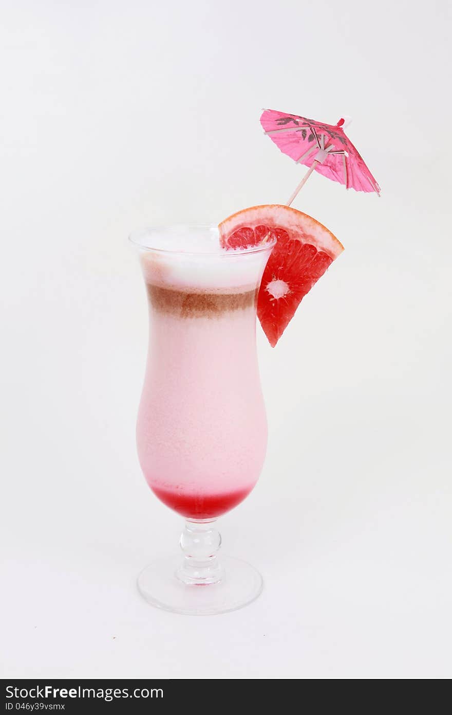 Cocktail glass with fresh grapefruit and umbrella