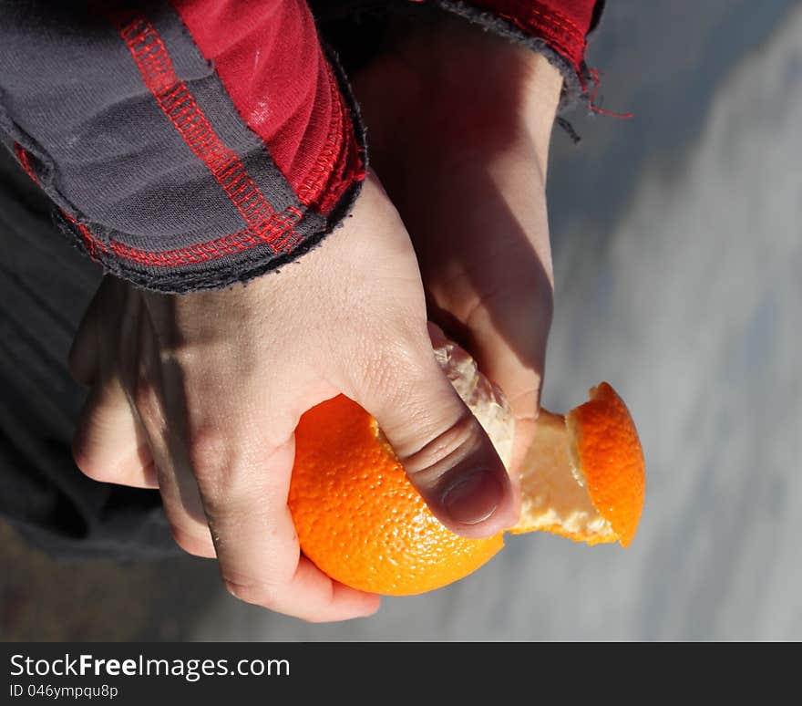 Close up of a Mans hand peeling an orange