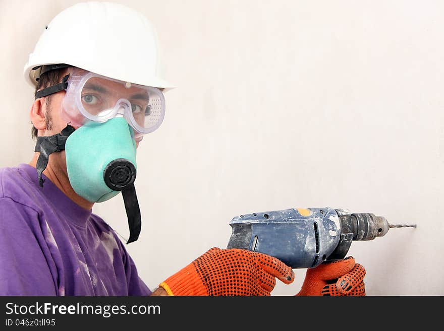 Worker in a hardhat holding electric drill. Worker in a hardhat holding electric drill