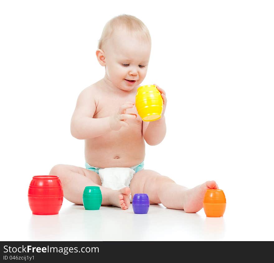 Cute little child is playing with toys while sitting on floor over white. Cute little child is playing with toys while sitting on floor over white