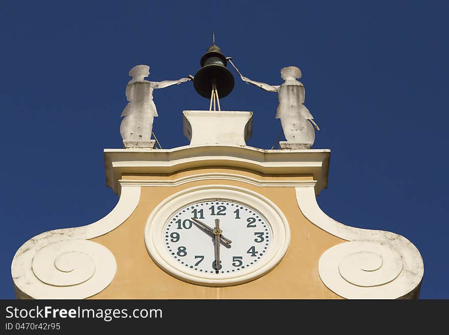 Clock Tower at Town Hall. Above the clock's bell and figures of two craftsmen. (Bardolino, Lake Garda, Italy). Clock Tower at Town Hall. Above the clock's bell and figures of two craftsmen. (Bardolino, Lake Garda, Italy)