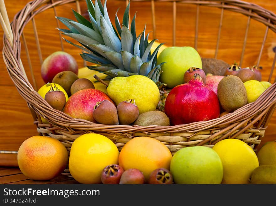 European fruits and tropical fruits in the wicker basket on the table