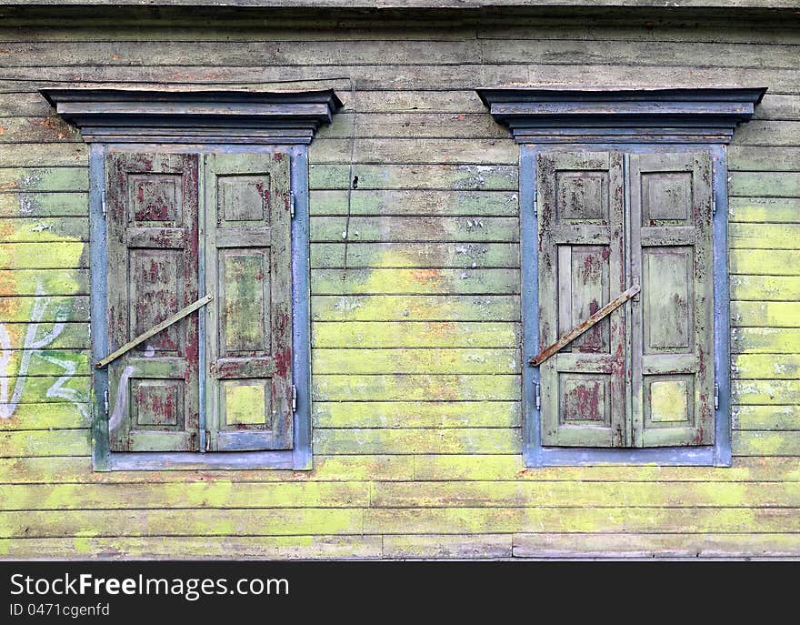 Old house, sun-blind. Broken paint layers. Colored, wooden wall. Old house, sun-blind. Broken paint layers. Colored, wooden wall