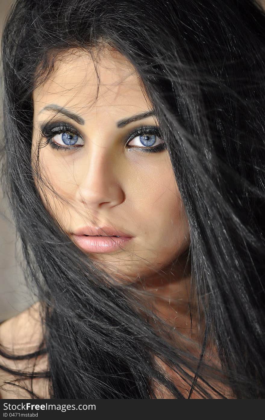 Portrait of a beautiful woman with blue eyes emphasized with black makeup