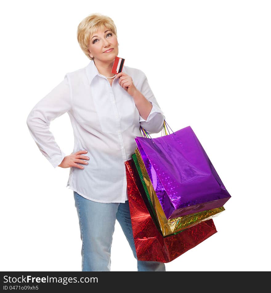 The woman with a credit card and purchases pensively looks upwards and dreams of new buying