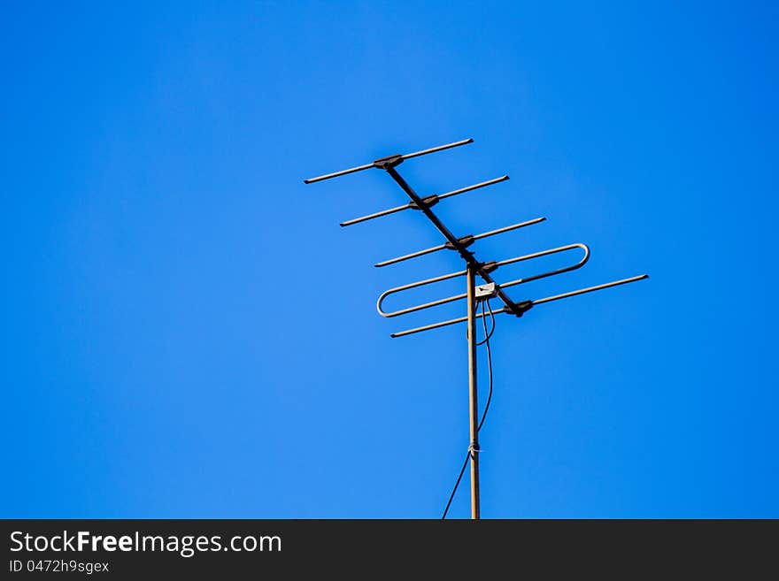 Home television antenna in a blue sky background. Home television antenna in a blue sky background