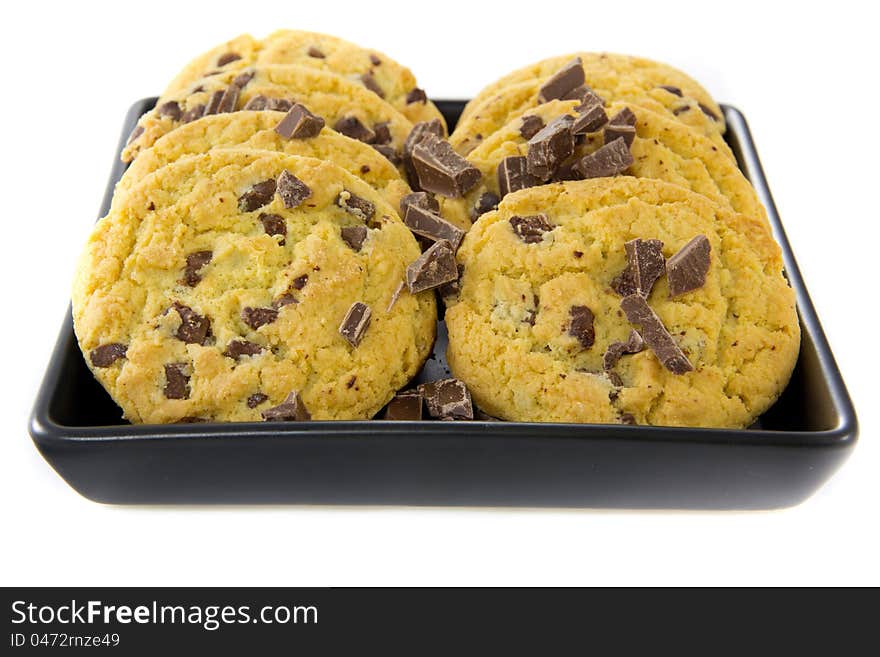 A picture of two stacks of some chocolate cookies with some chocolate on a black plate. A picture of two stacks of some chocolate cookies with some chocolate on a black plate