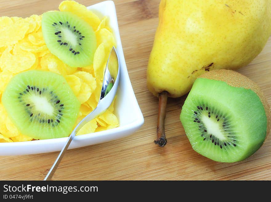 Healthy and light snack; corn flakes, pear and kiwi on the table. Healthy and light snack; corn flakes, pear and kiwi on the table.