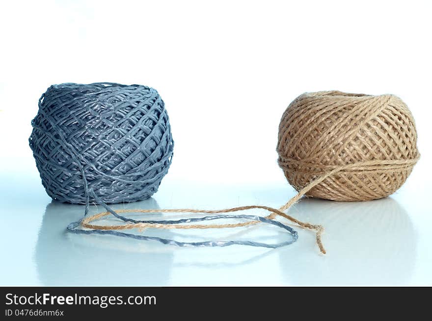 Two balls of twine on a white background