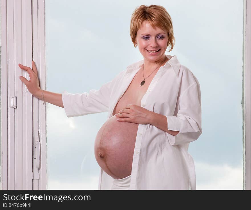 Pregnant woman standing by the window